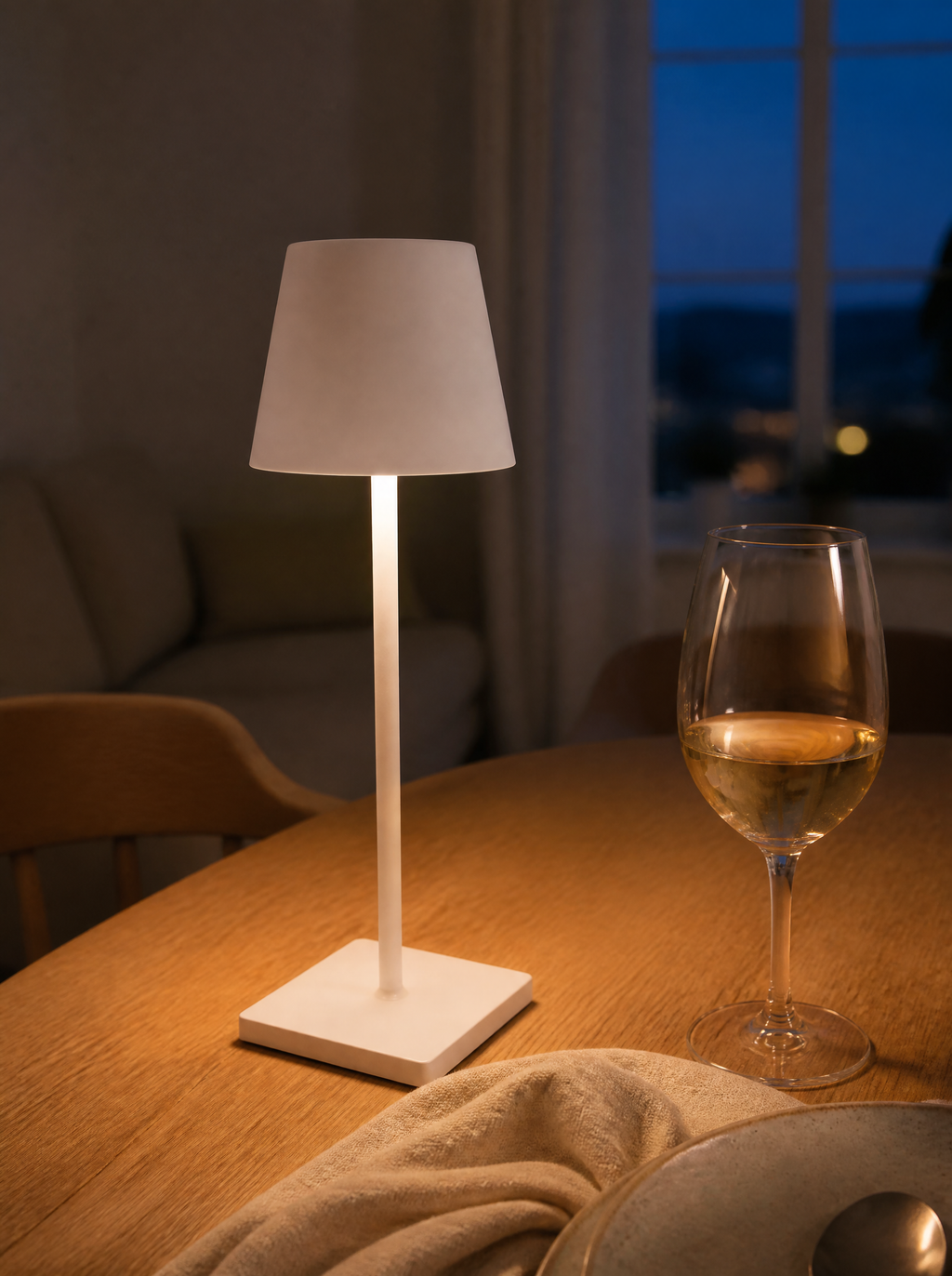 White cordless bistro lamp glowing on a dinner table